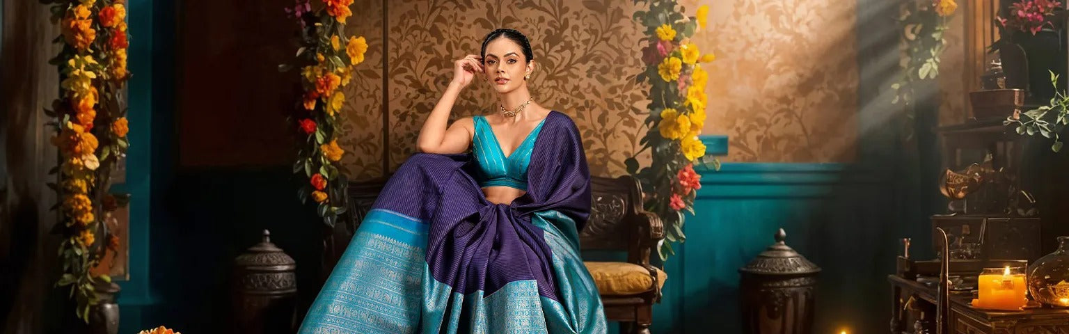 Woman in a blue and purple traditional outfit sitting in an ornate room with floral decorations.